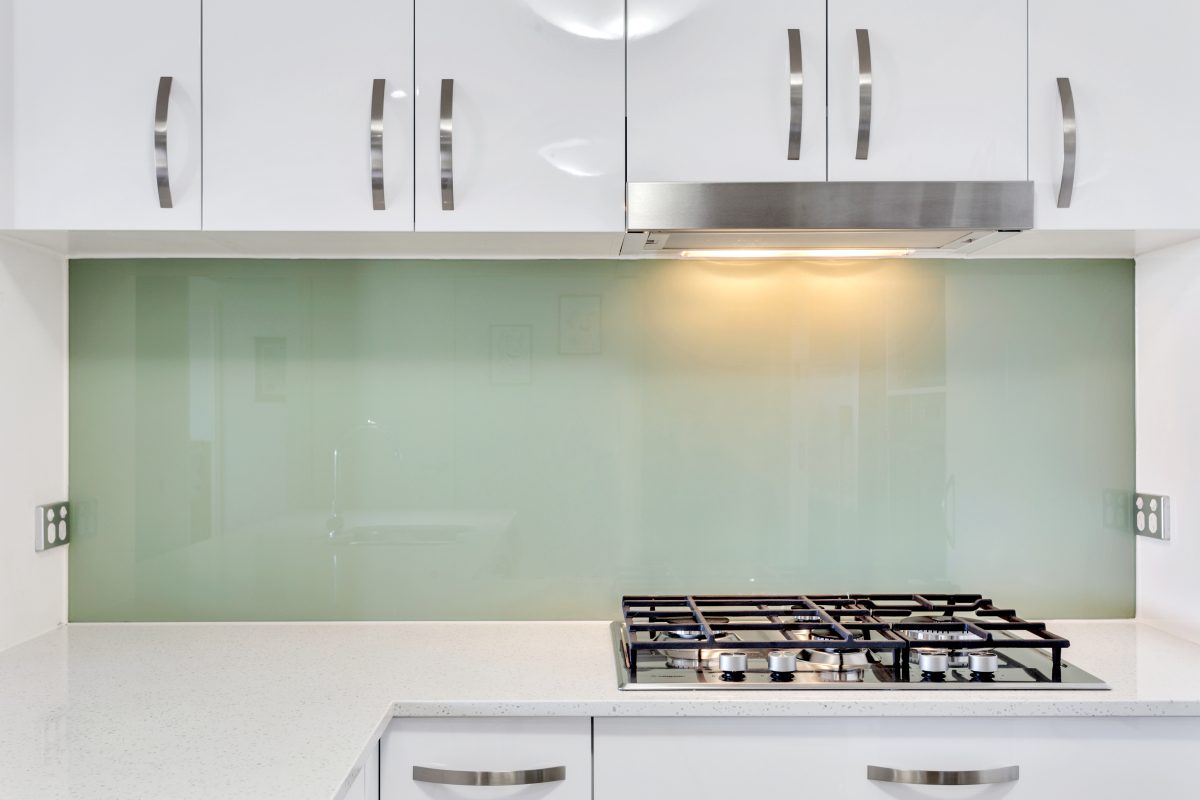 Stone top and gas cooktop with glass splashback